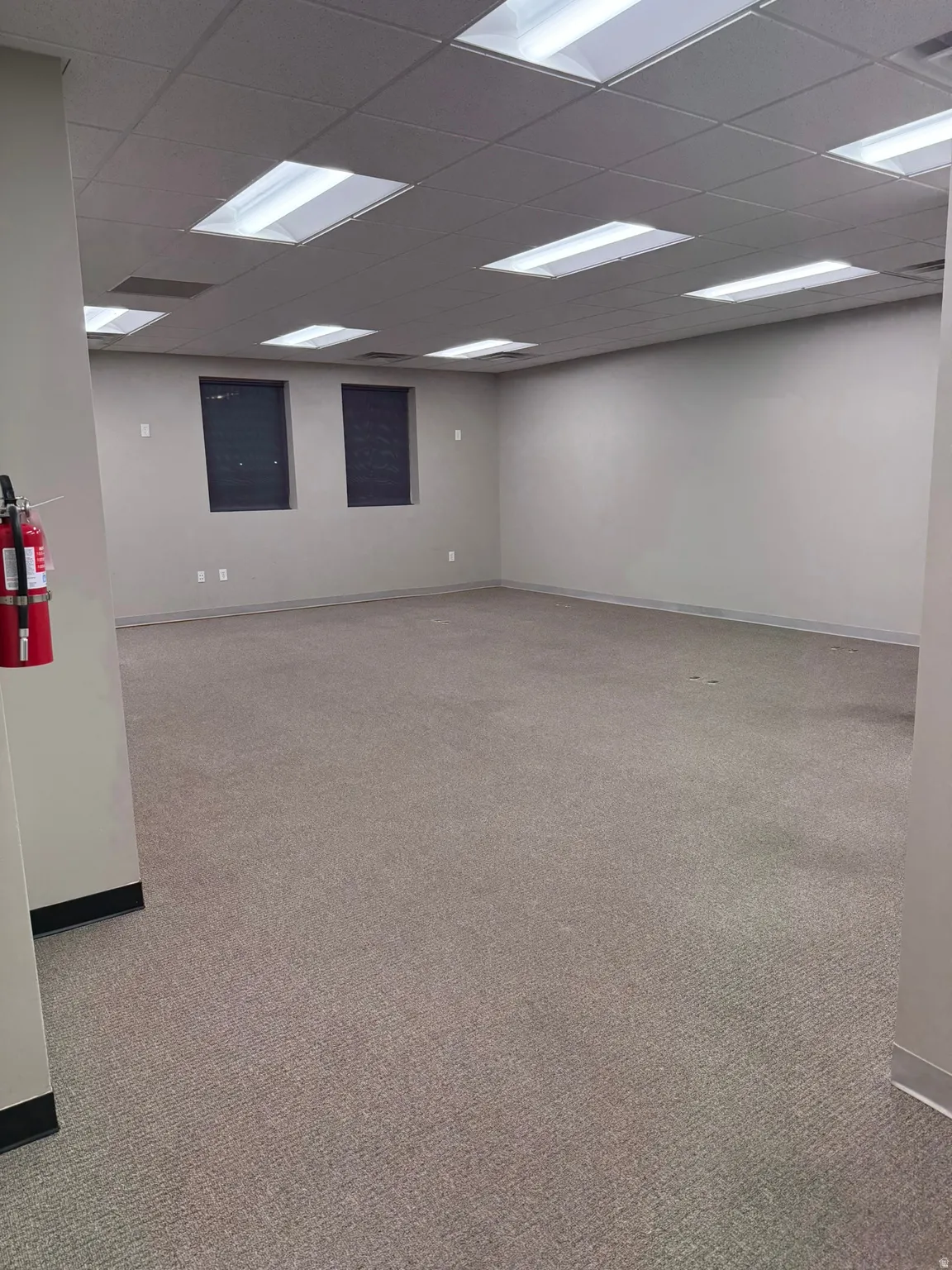 Spare room with light carpet and a drop ceiling