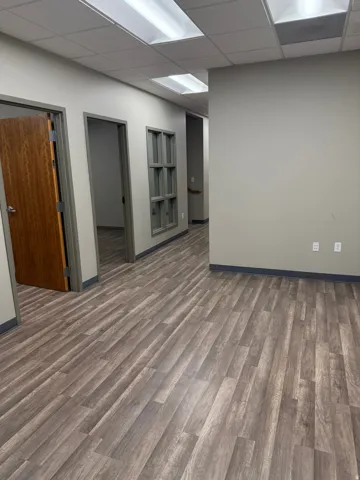 Empty room with wood finished floors and a drop ceiling