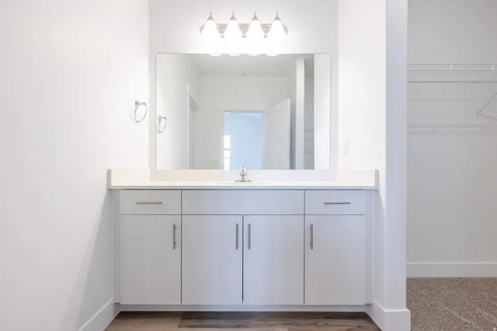 Contemporary vanity featuring a rectangular undermount sink, light-toned countertop, and chrome faucet
