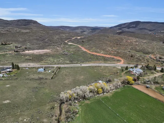 Aerial view of property and surrounding area featuring a mountain backdrop and rural landscape
