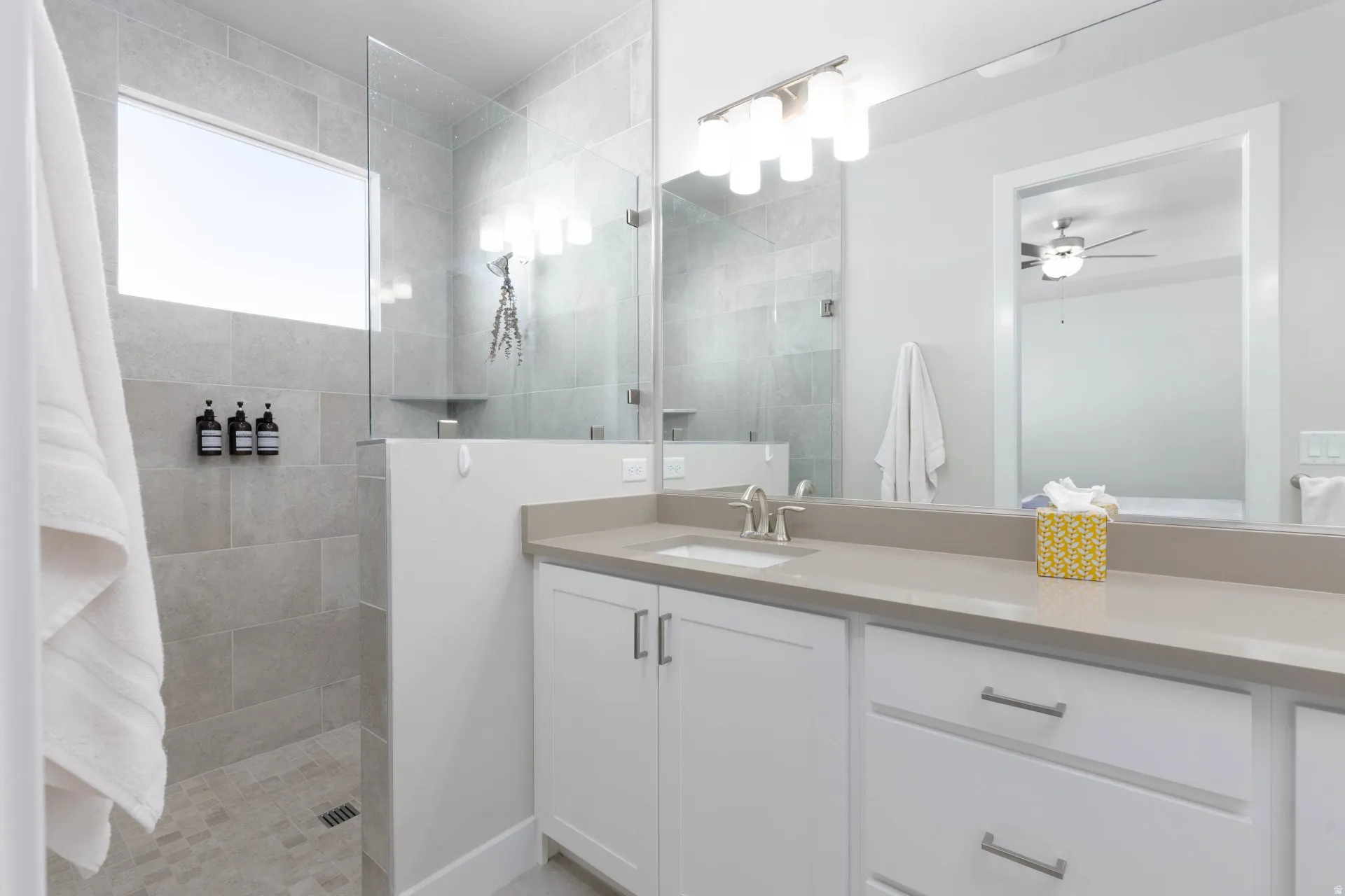 Full bath featuring walk in shower, vanity, and a ceiling fan