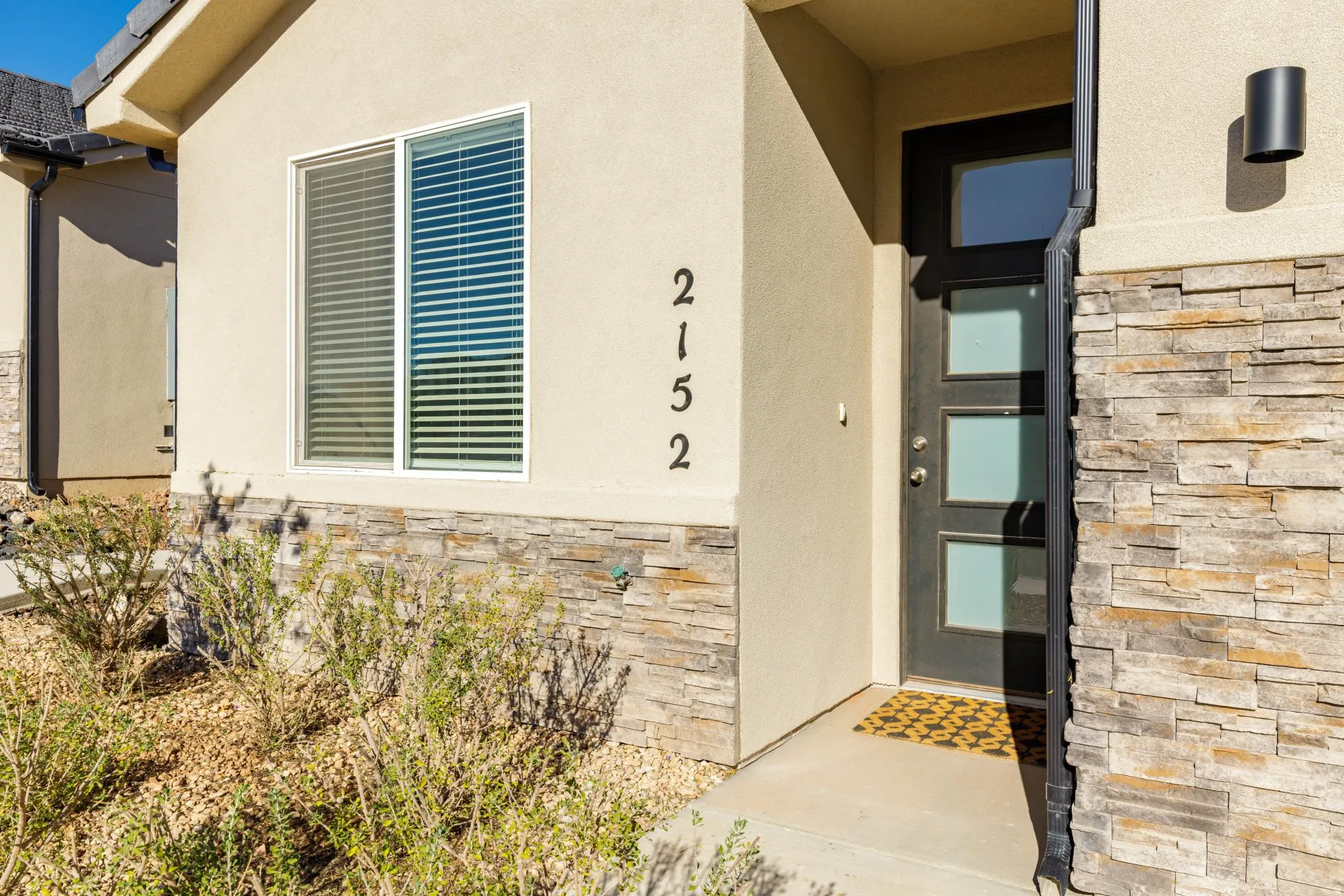 Doorway to property with stone siding and stucco siding