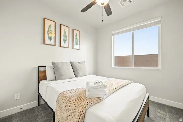 Bedroom featuring a ceiling fan and carpet