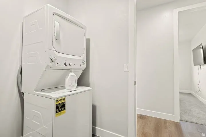 Washroom featuring estacked washer and dryer and light wood finished floors