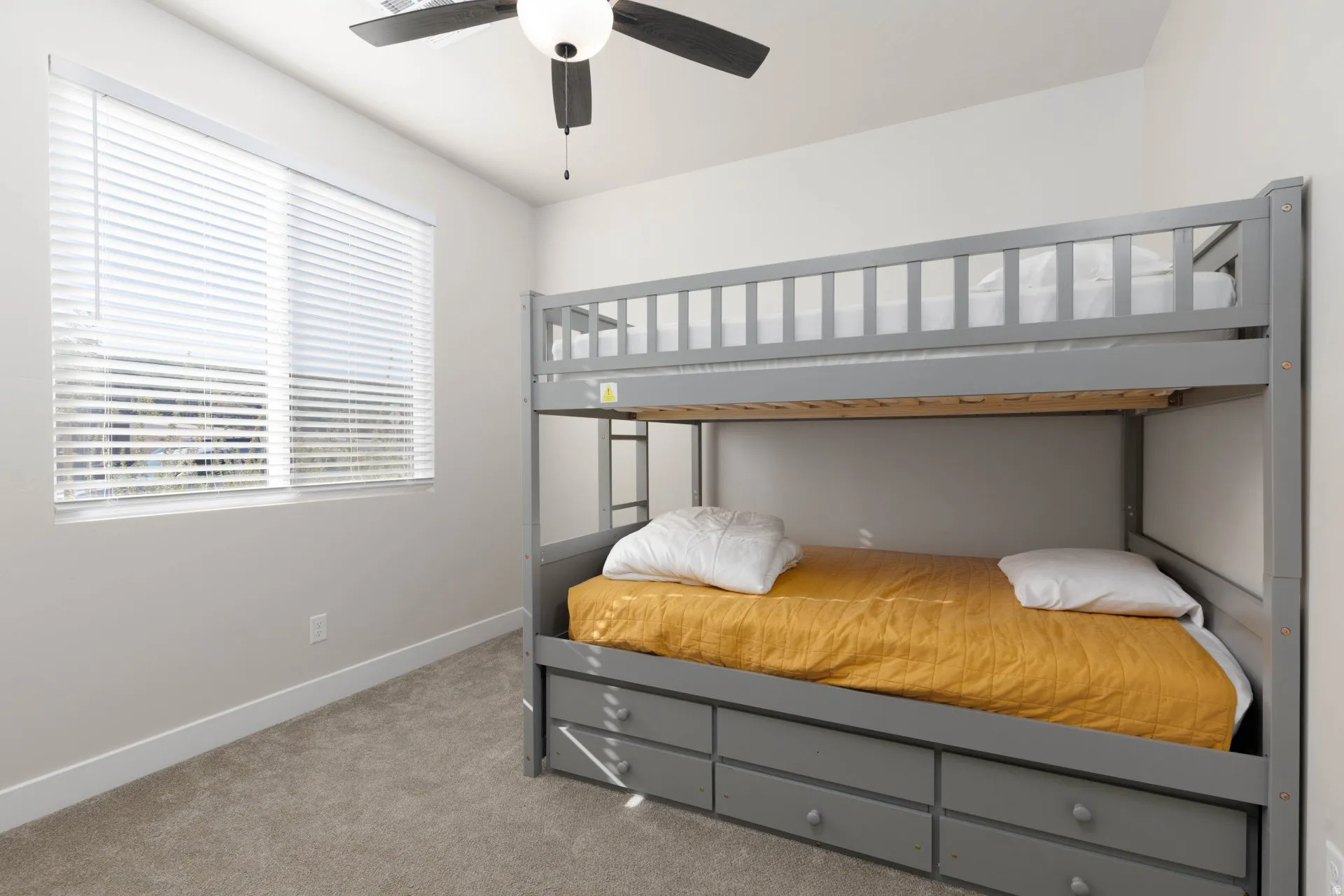 Bedroom with light colored carpet and a ceiling fan