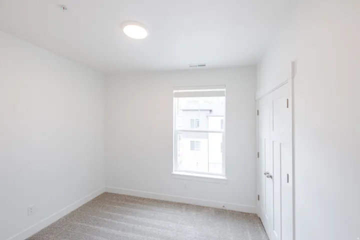 Neutral white walls complement light-colored carpeting