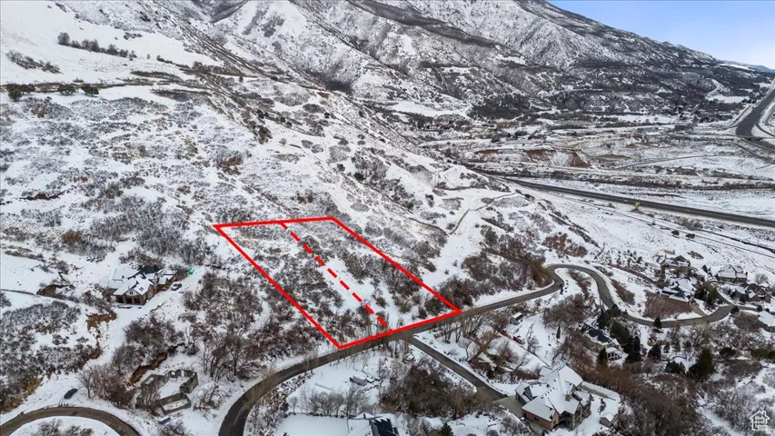 Snowy aerial view with property parcel outlined and a mountain view