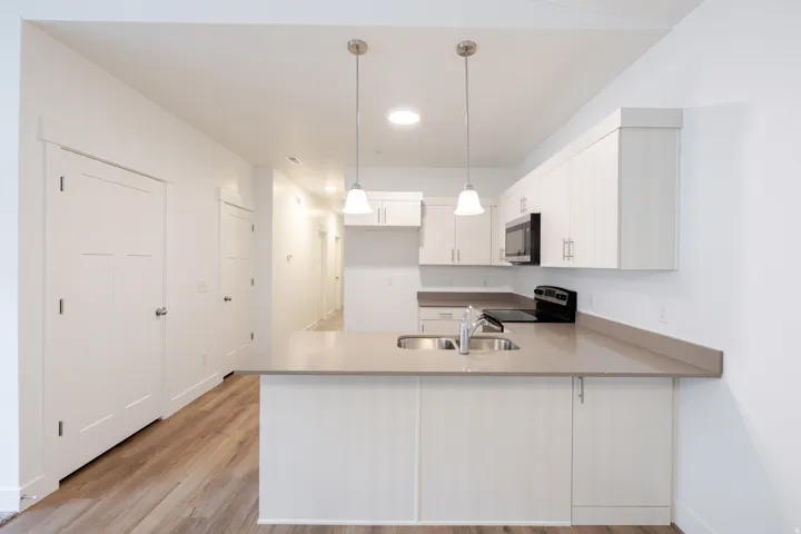 Kitchen featuring light-toned cabinetry, light gray countertops, and modern pendant lighting