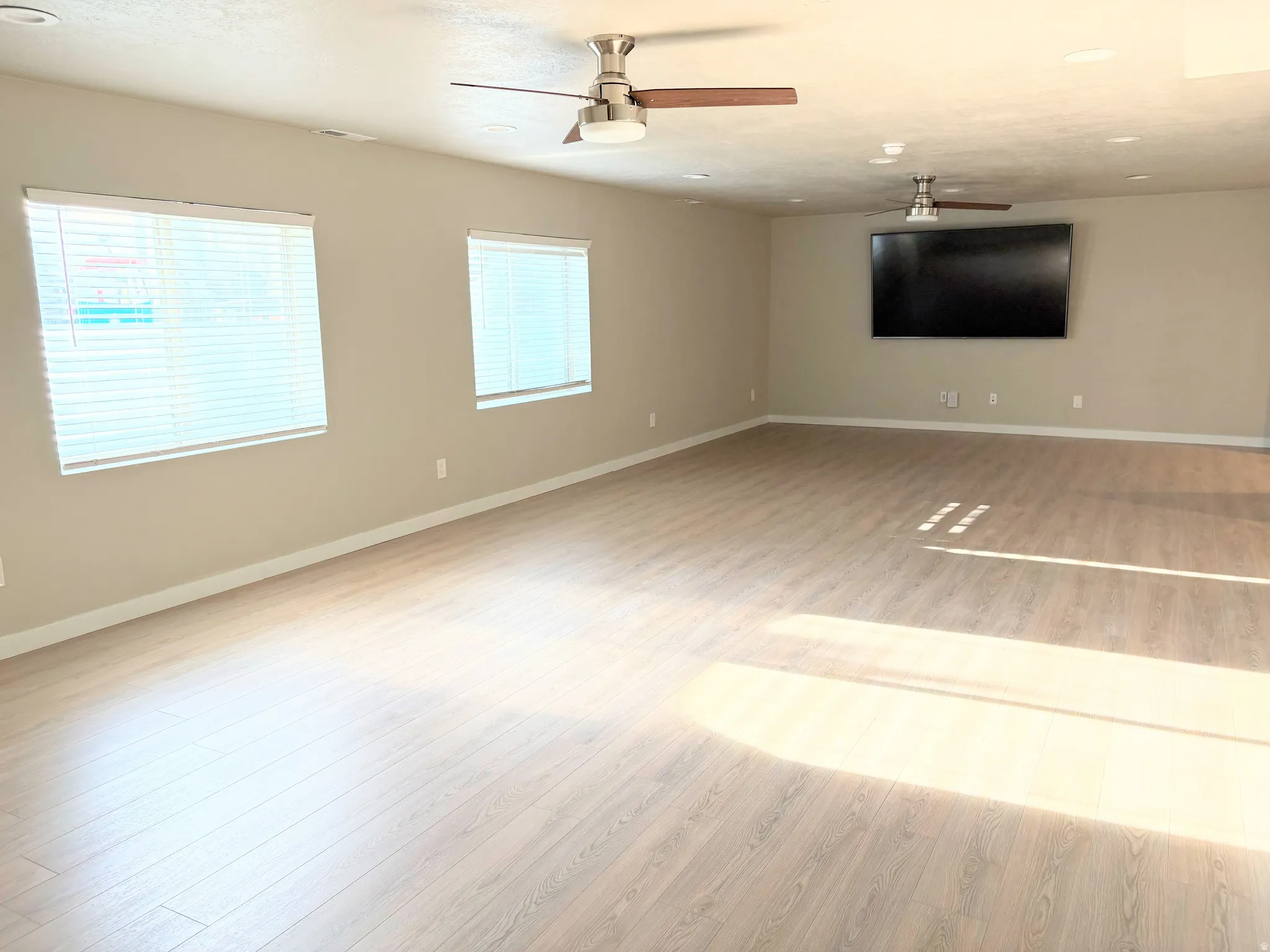 Spare room featuring light wood-type flooring and a ceiling fan