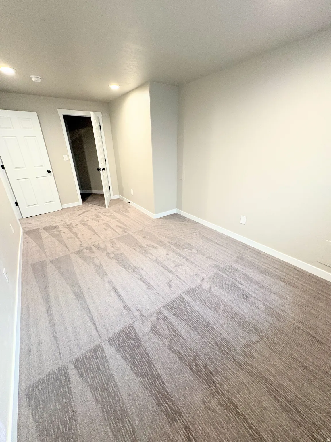 Unfurnished room with light carpet and recessed lighting