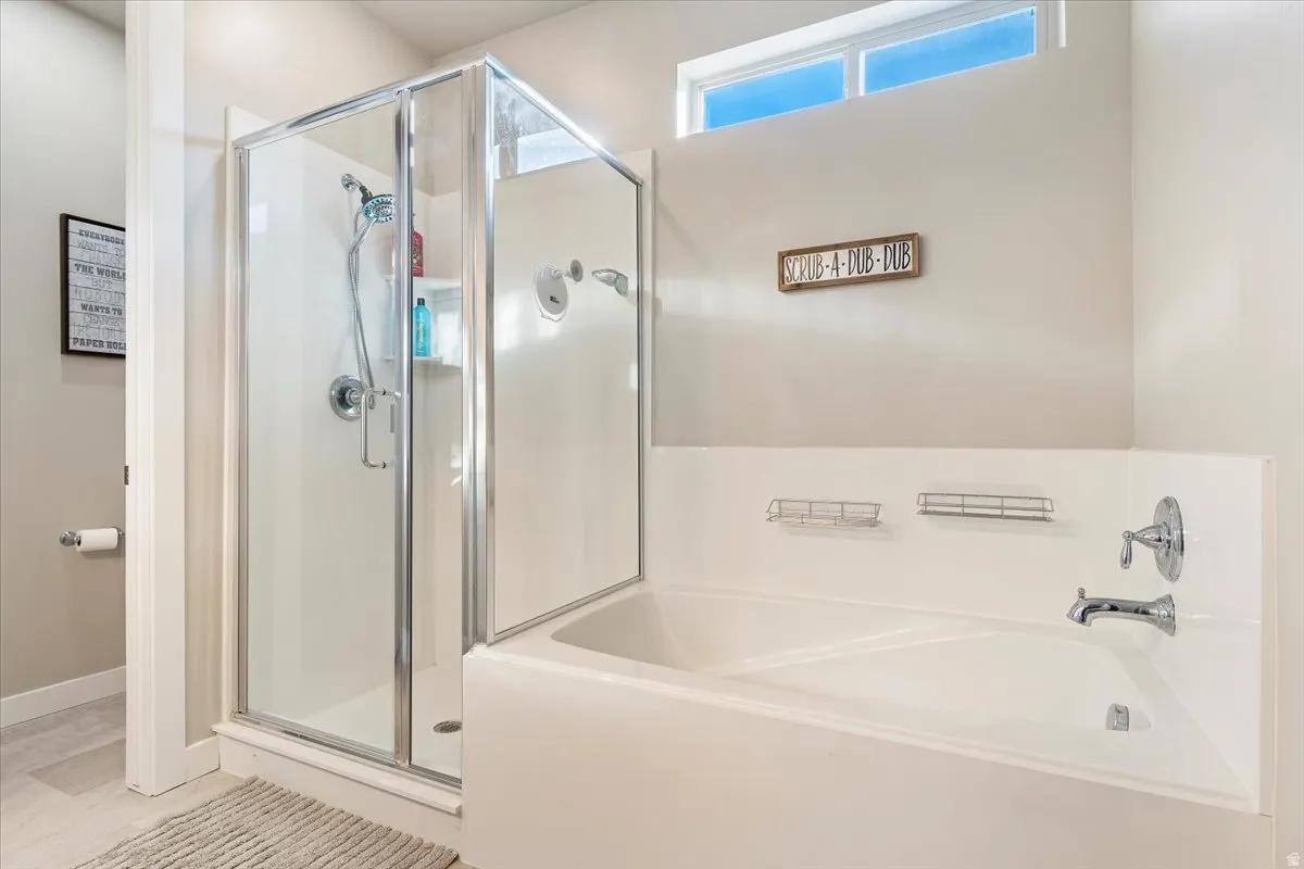 Bathroom featuring a garden tub and a shower stall