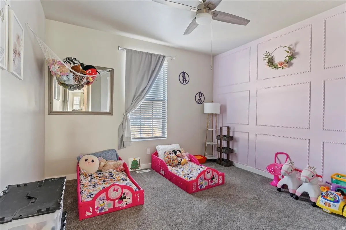 Recreation room with carpet floors and a ceiling fan