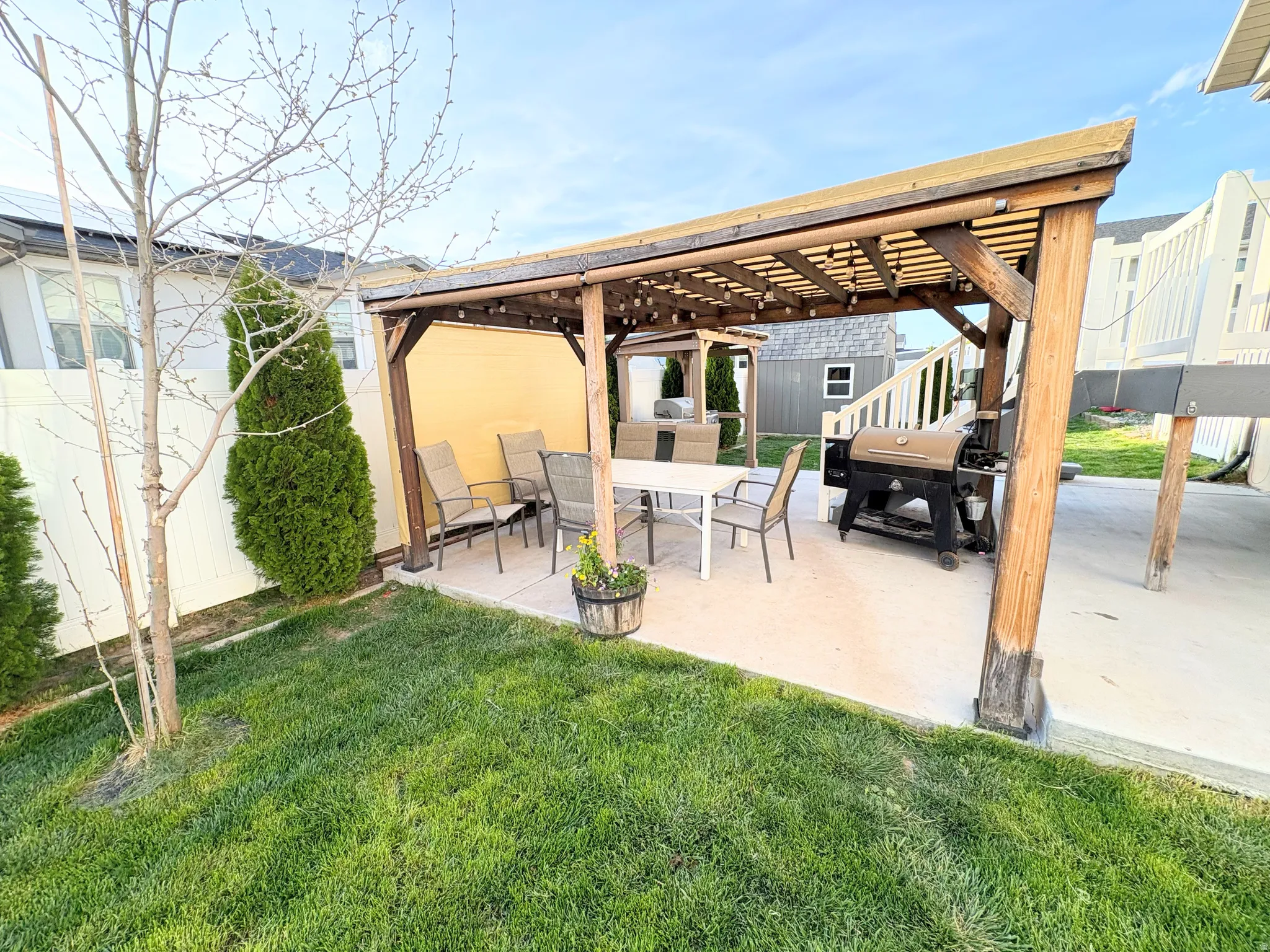 Fenced backyard featuring a patio, grilling area, a pergola, and outdoor dining area