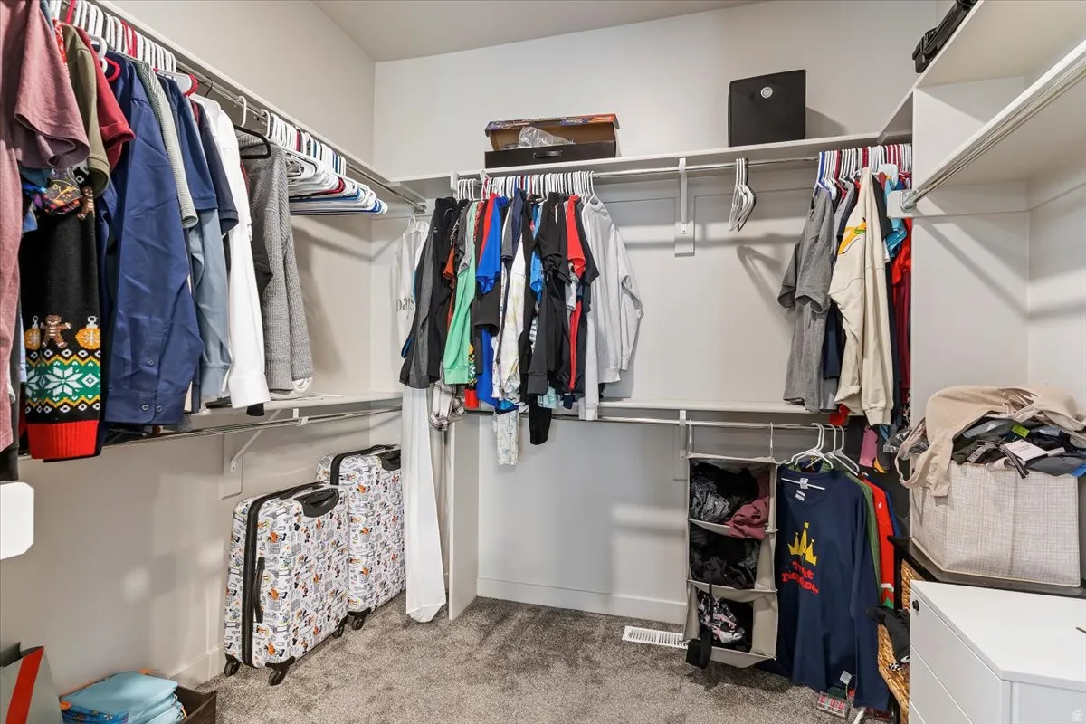Spacious closet with light colored carpet