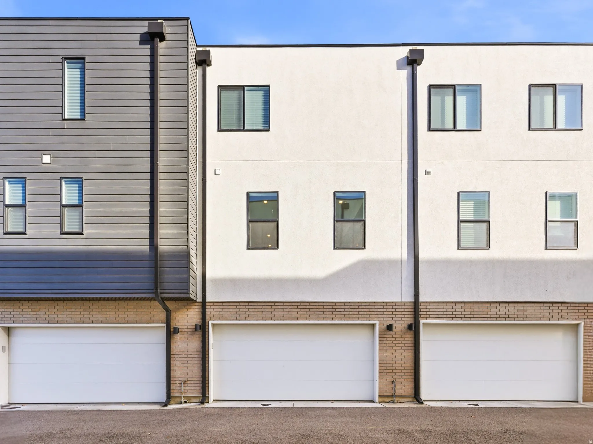 Rear view of property with brick siding and a garage