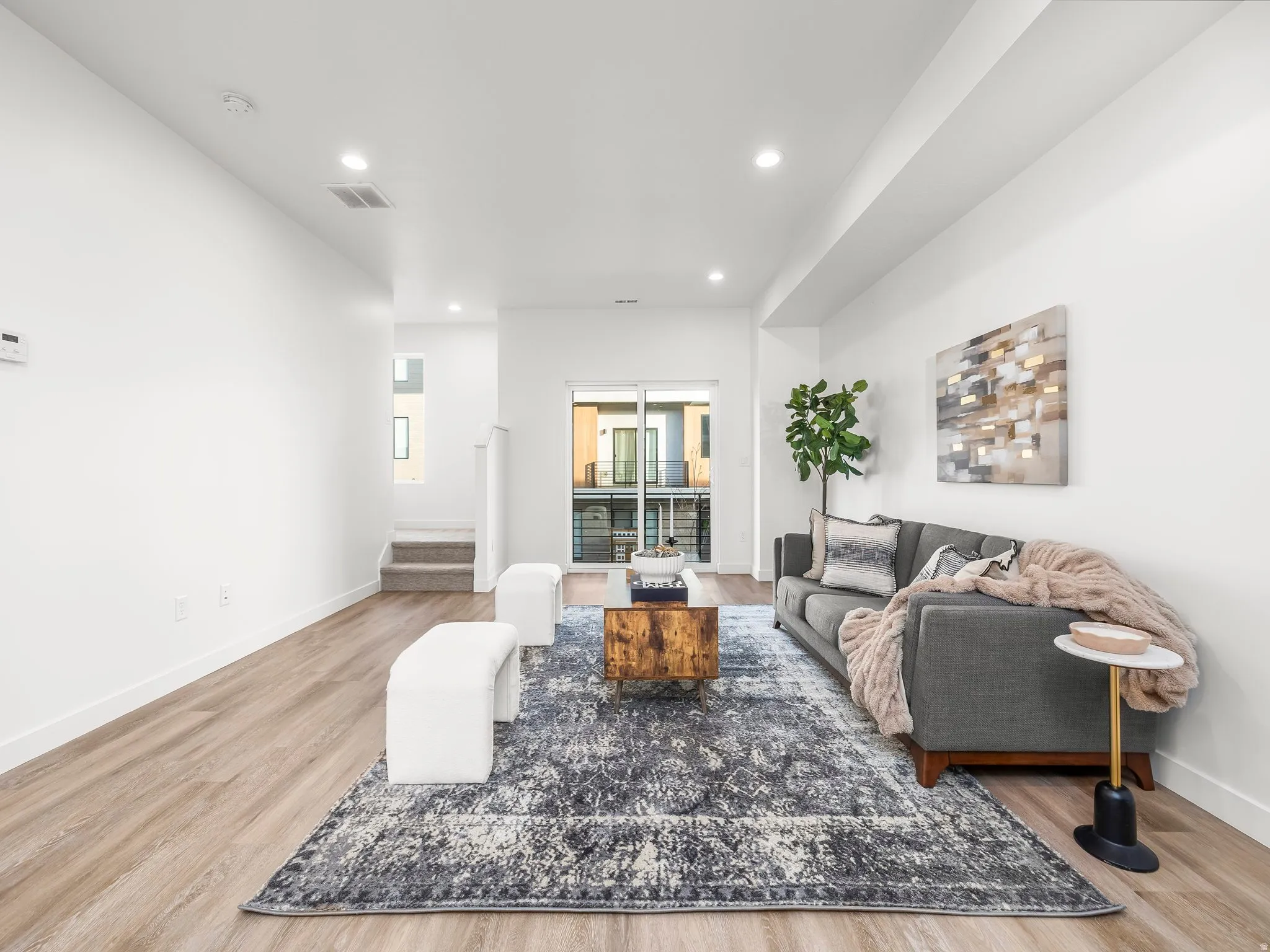 Living area featuring recessed lighting, light wood finished floors, and stairway