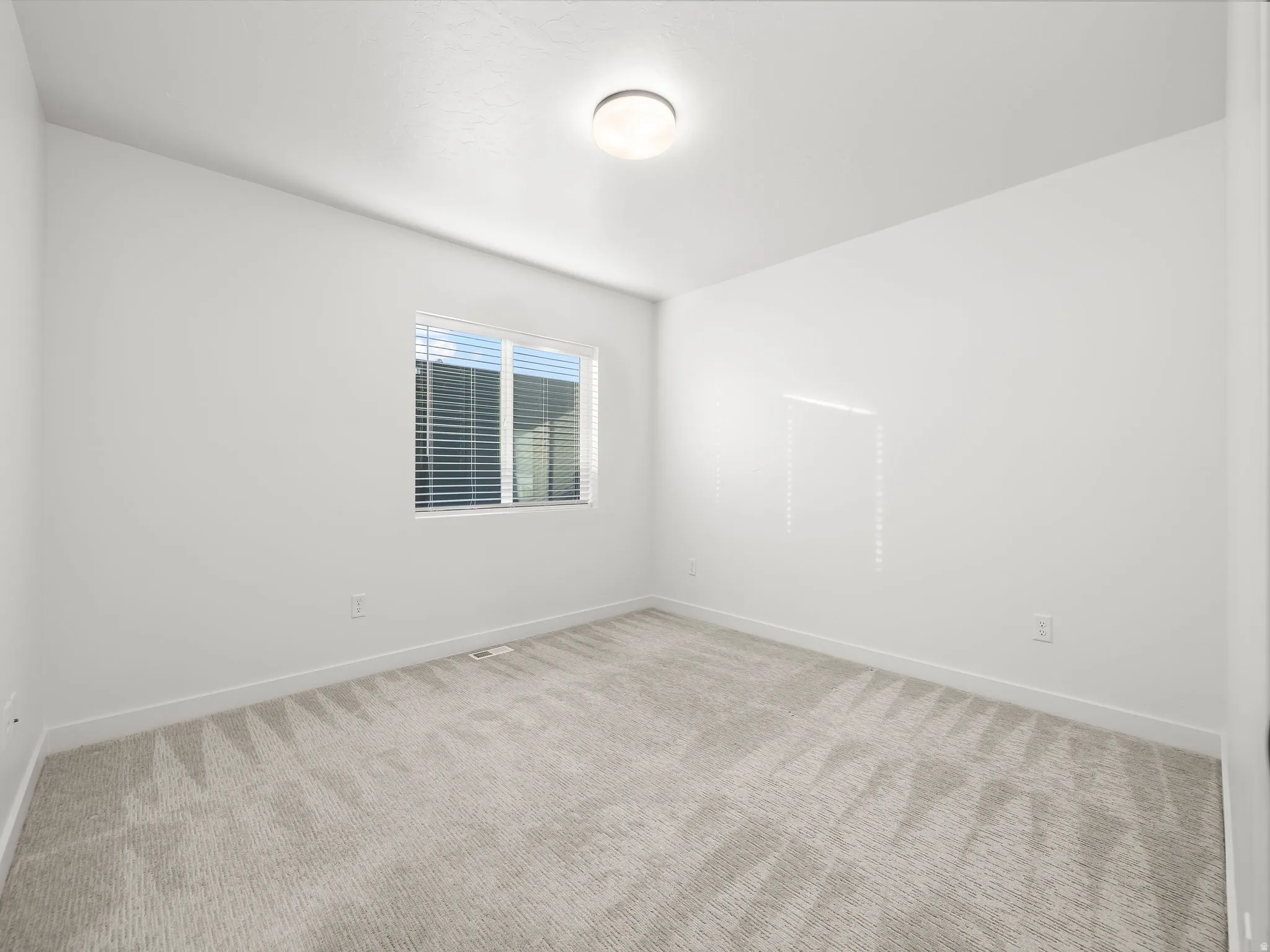 Empty room featuring carpet flooring and baseboards
