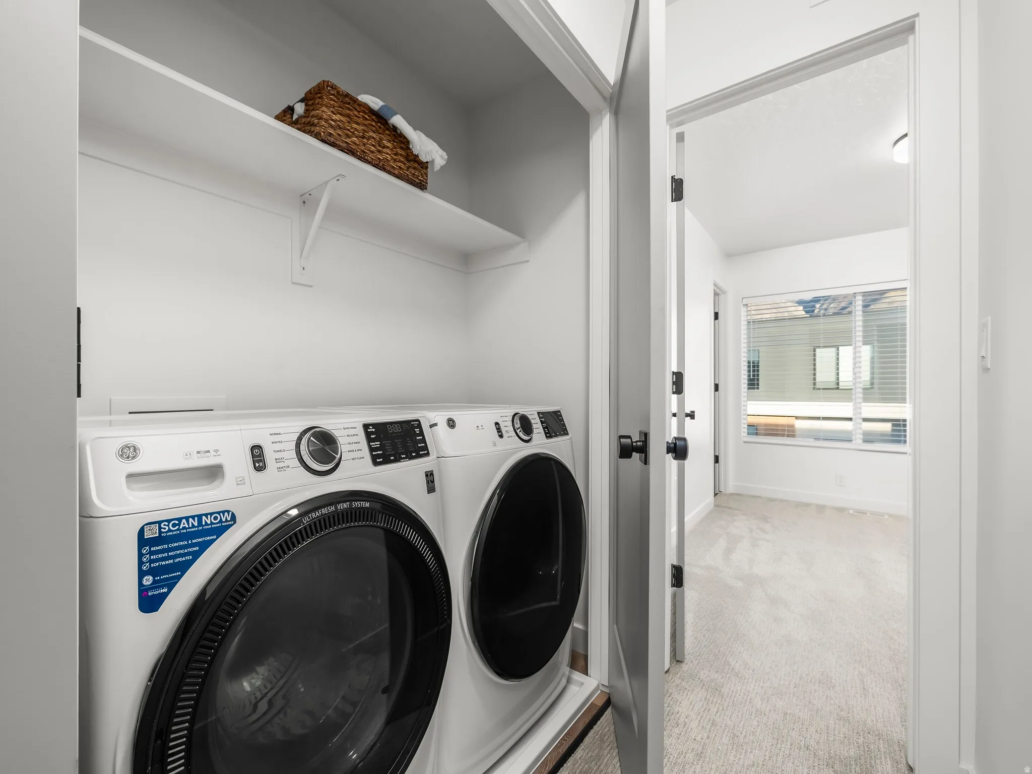 Washroom featuring light colored carpet and washer and dryer