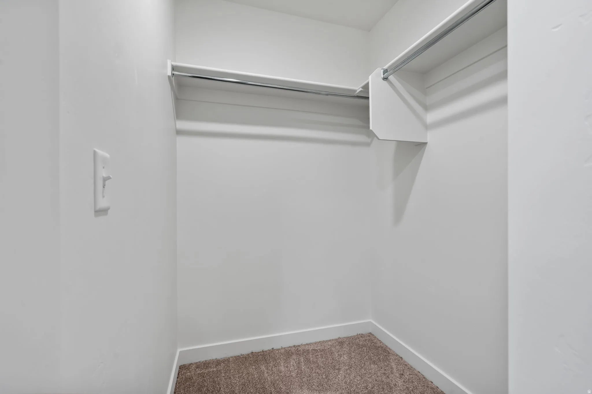 Walk in closet featuring light colored carpet