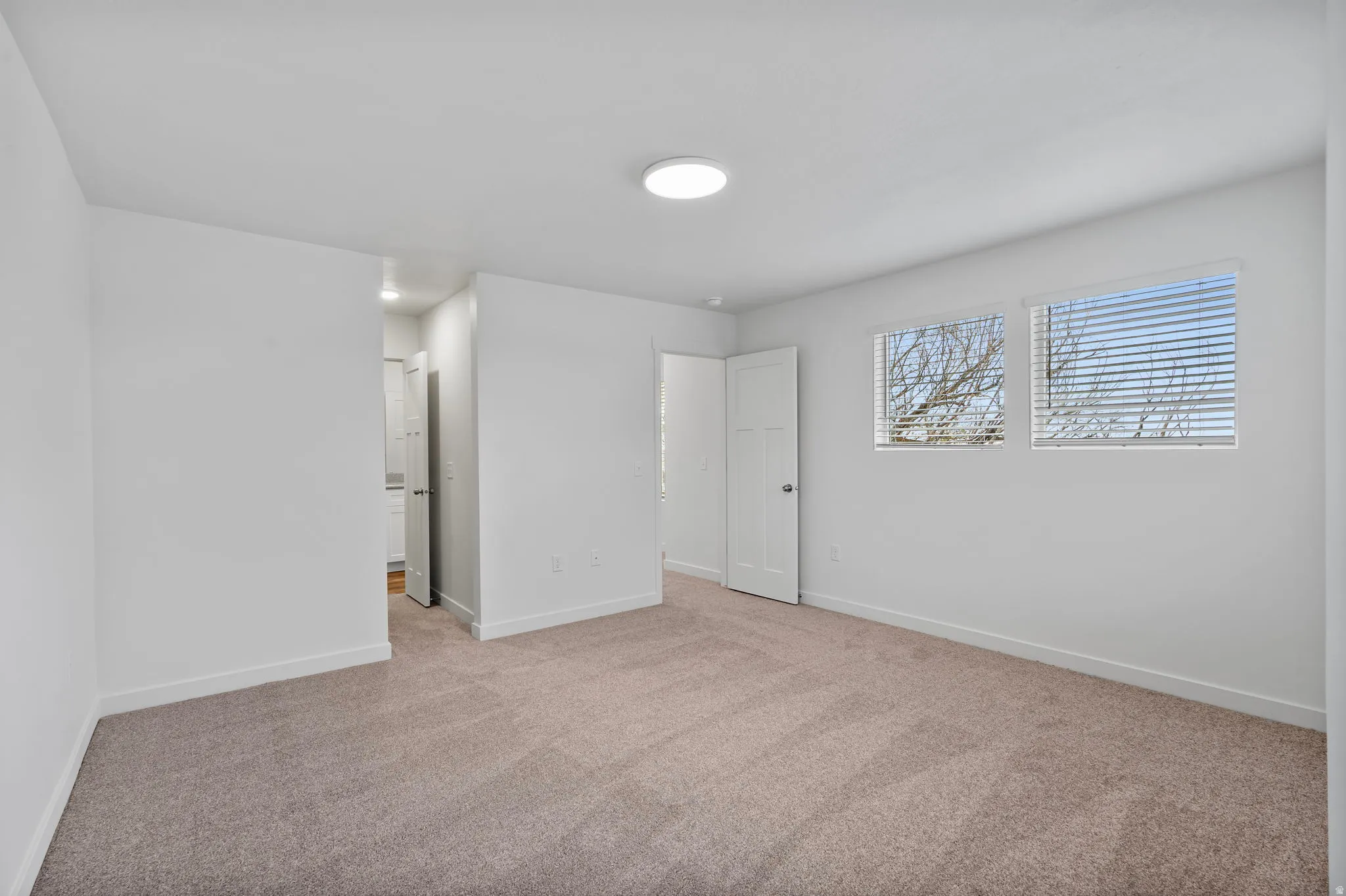 Unfurnished bedroom with carpet flooring and baseboards