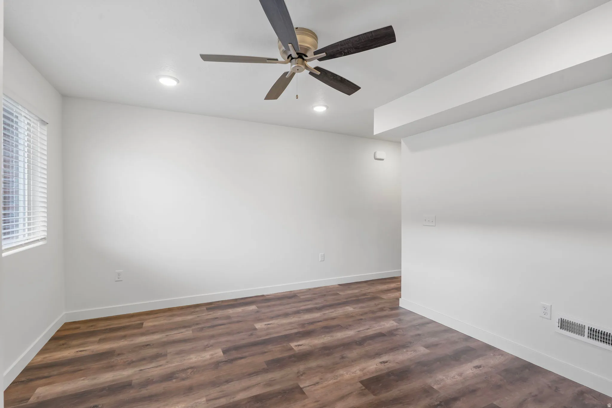 Spare room featuring ceiling fan, dark wood-style flooring, and recessed lighting