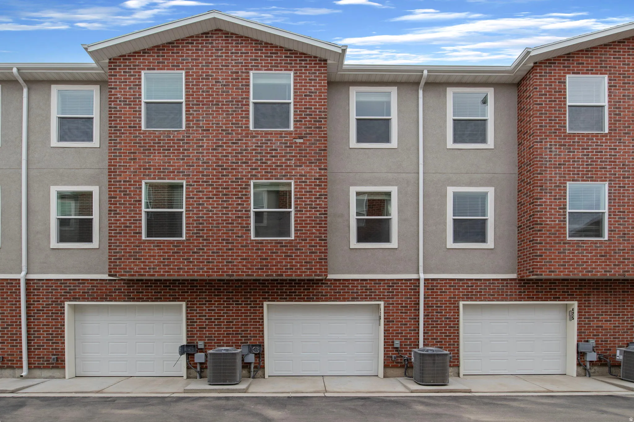Rear view of property featuring an attached garage and brick siding
