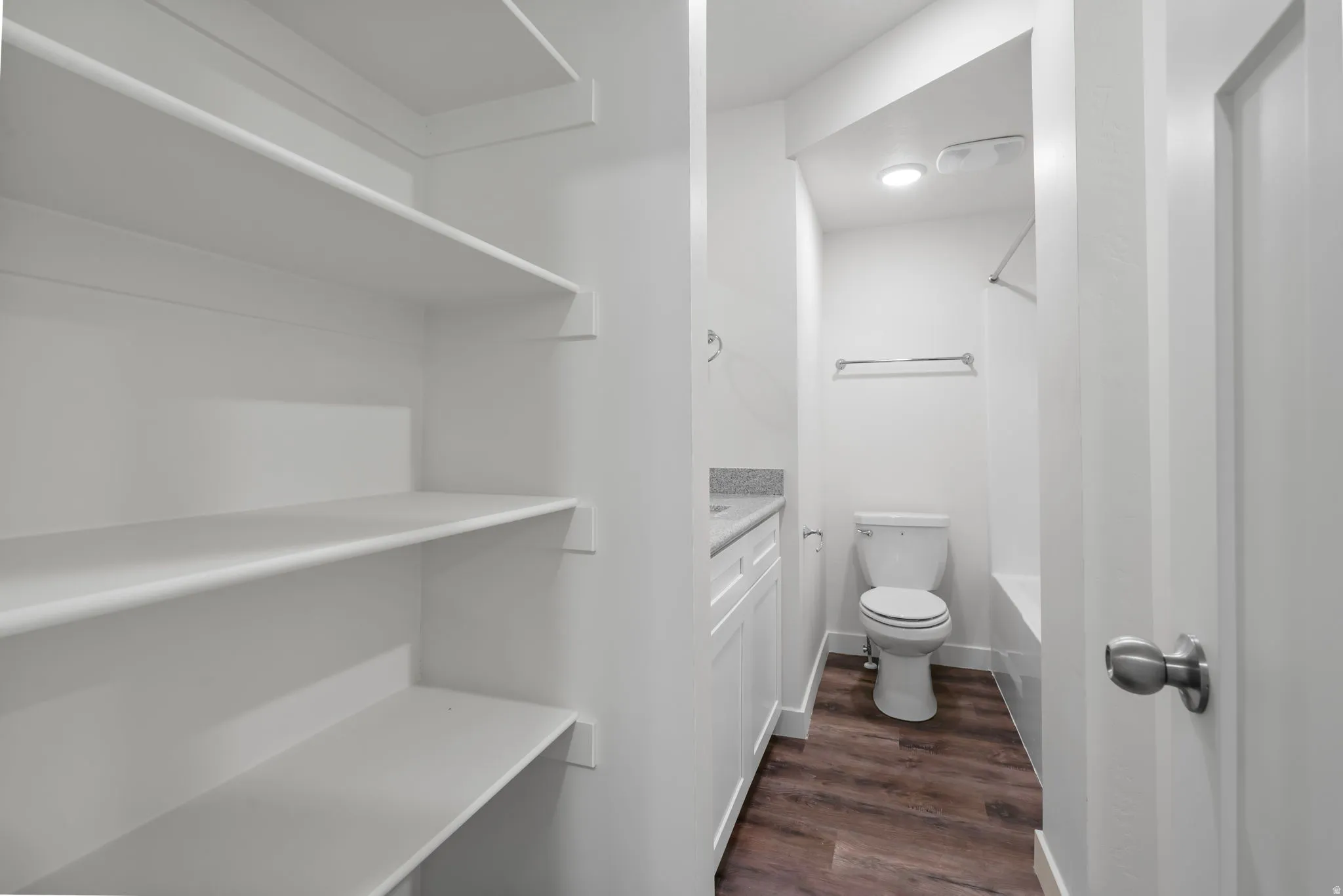 Full bathroom featuring vanity, dark wood-type flooring, and shower / tub combination