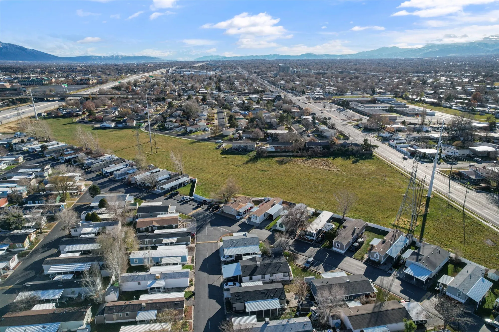 Aerial view of property and surrounding area with nearby suburban area and a mountainous background