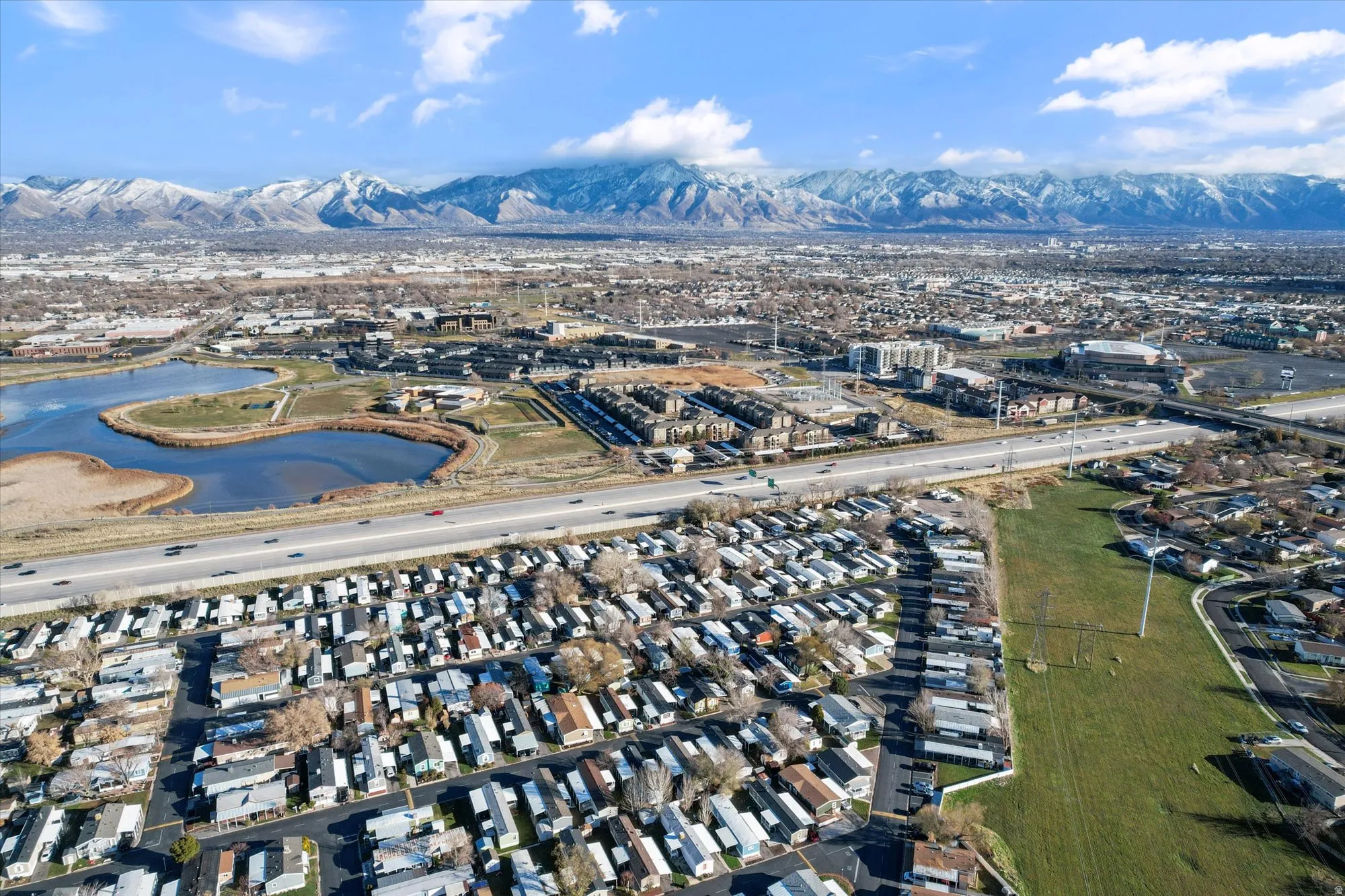 Aerial view of residential area featuring a mountain backdrop and a main thoroughfare