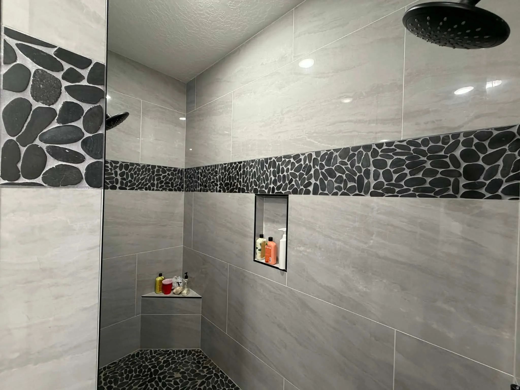 Full bath featuring a tile shower and a textured ceiling