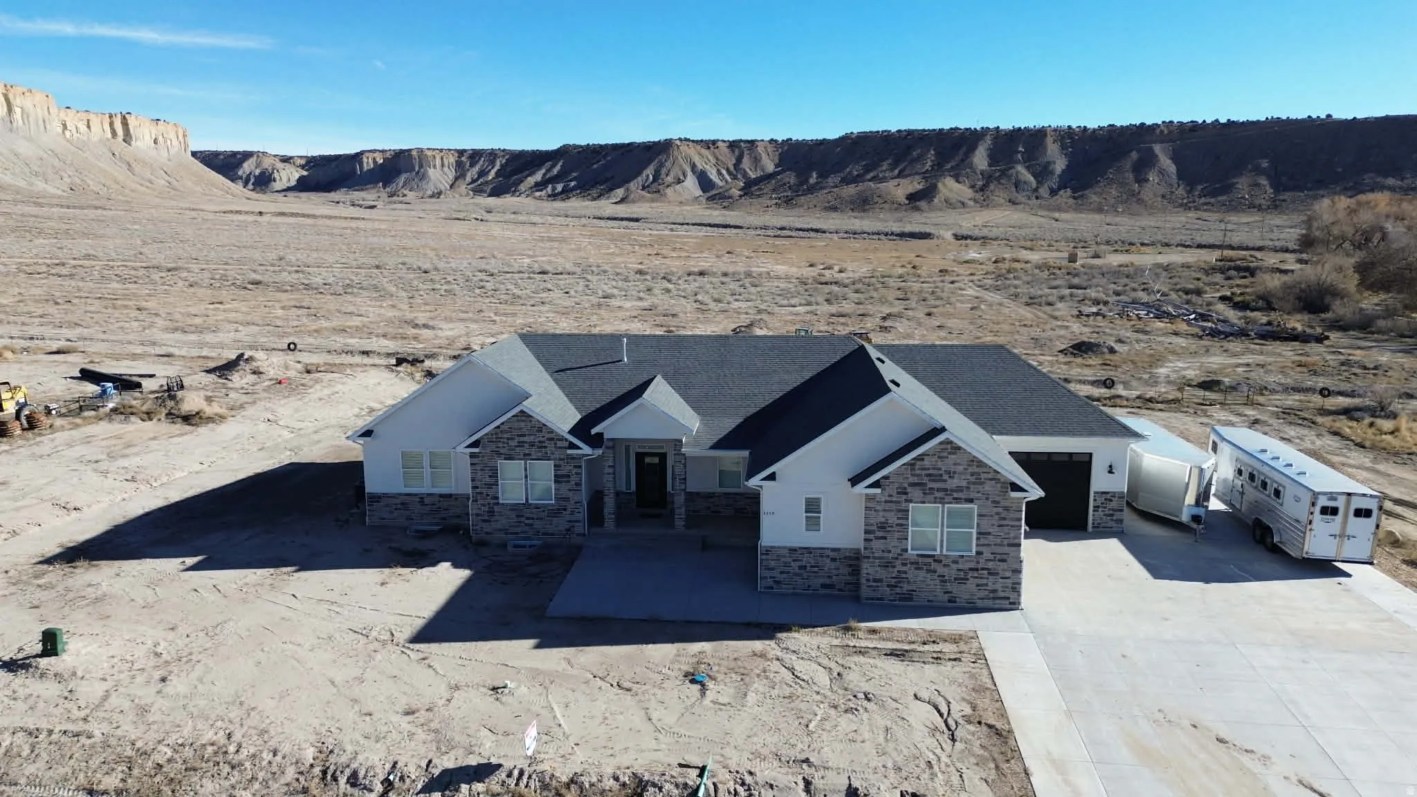 View of front of house with stone siding, concrete driveway, and an attached garage