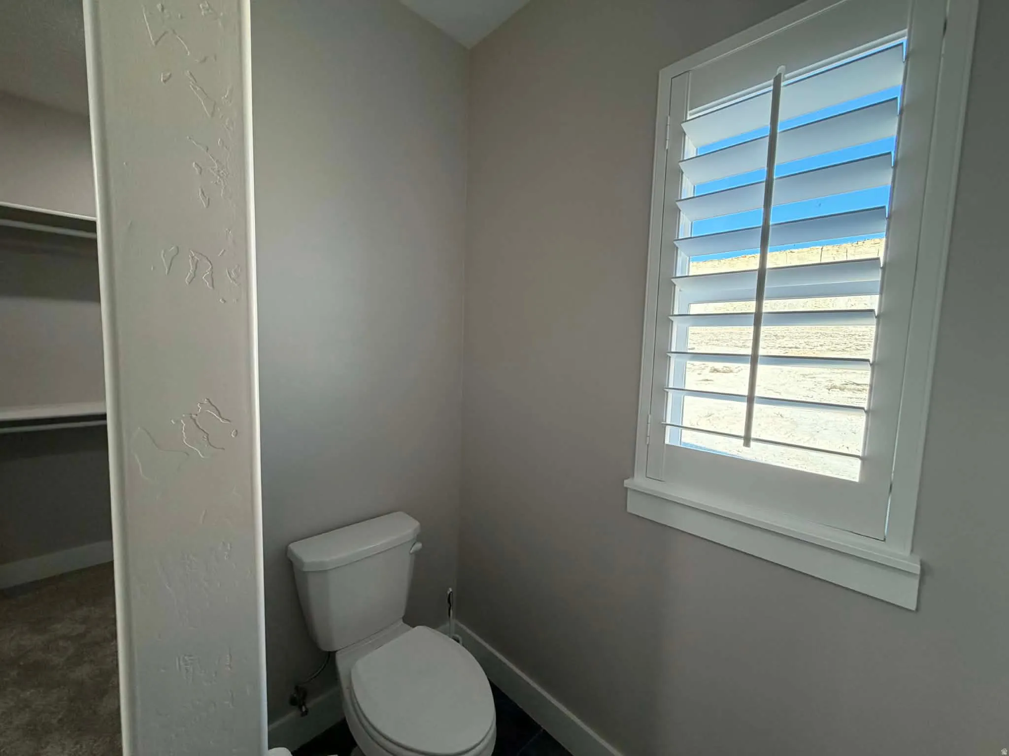 Bathroom featuring a spacious closet and a textured wall