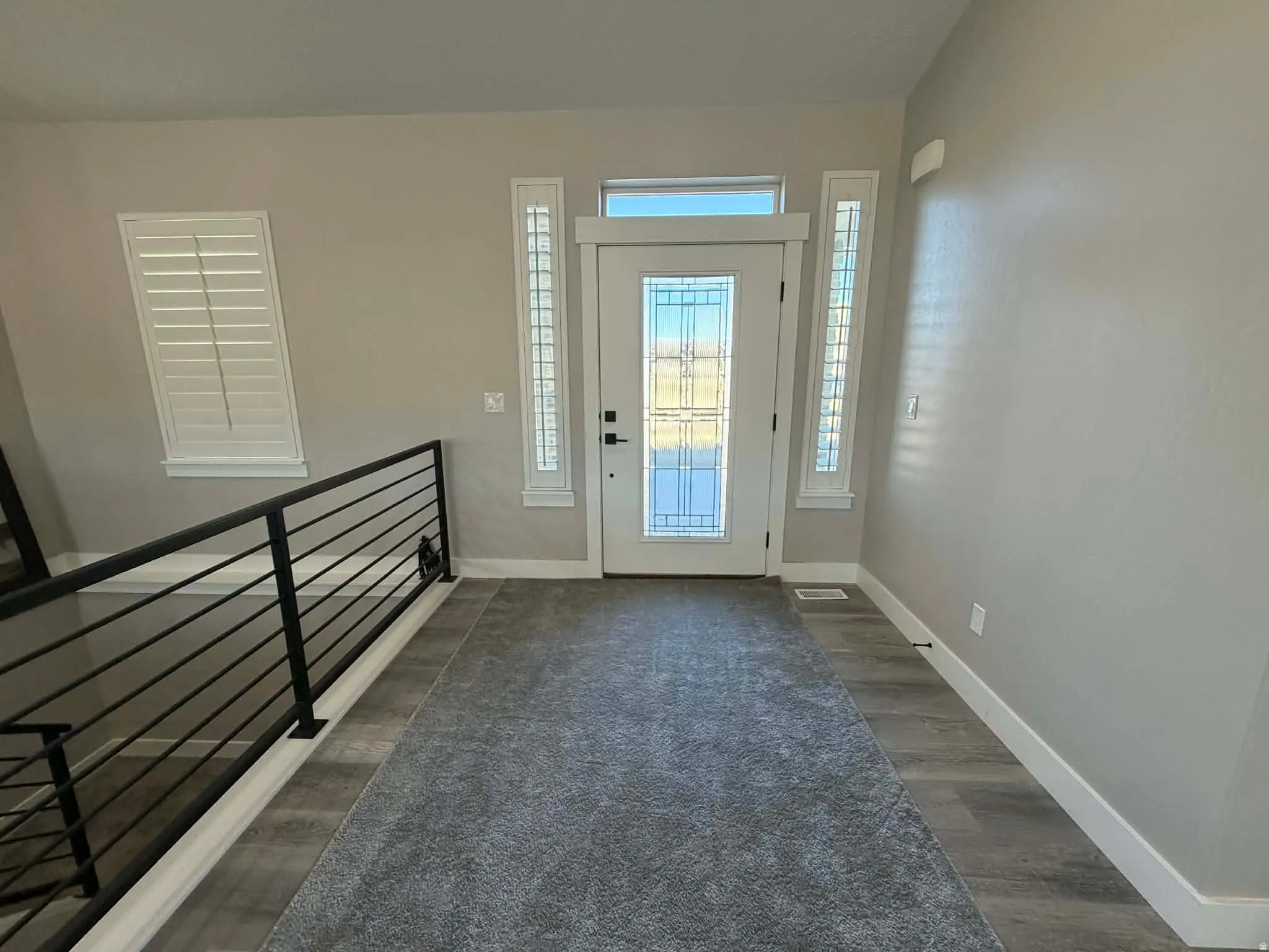 Entrance foyer with baseboards and dark wood-style floors