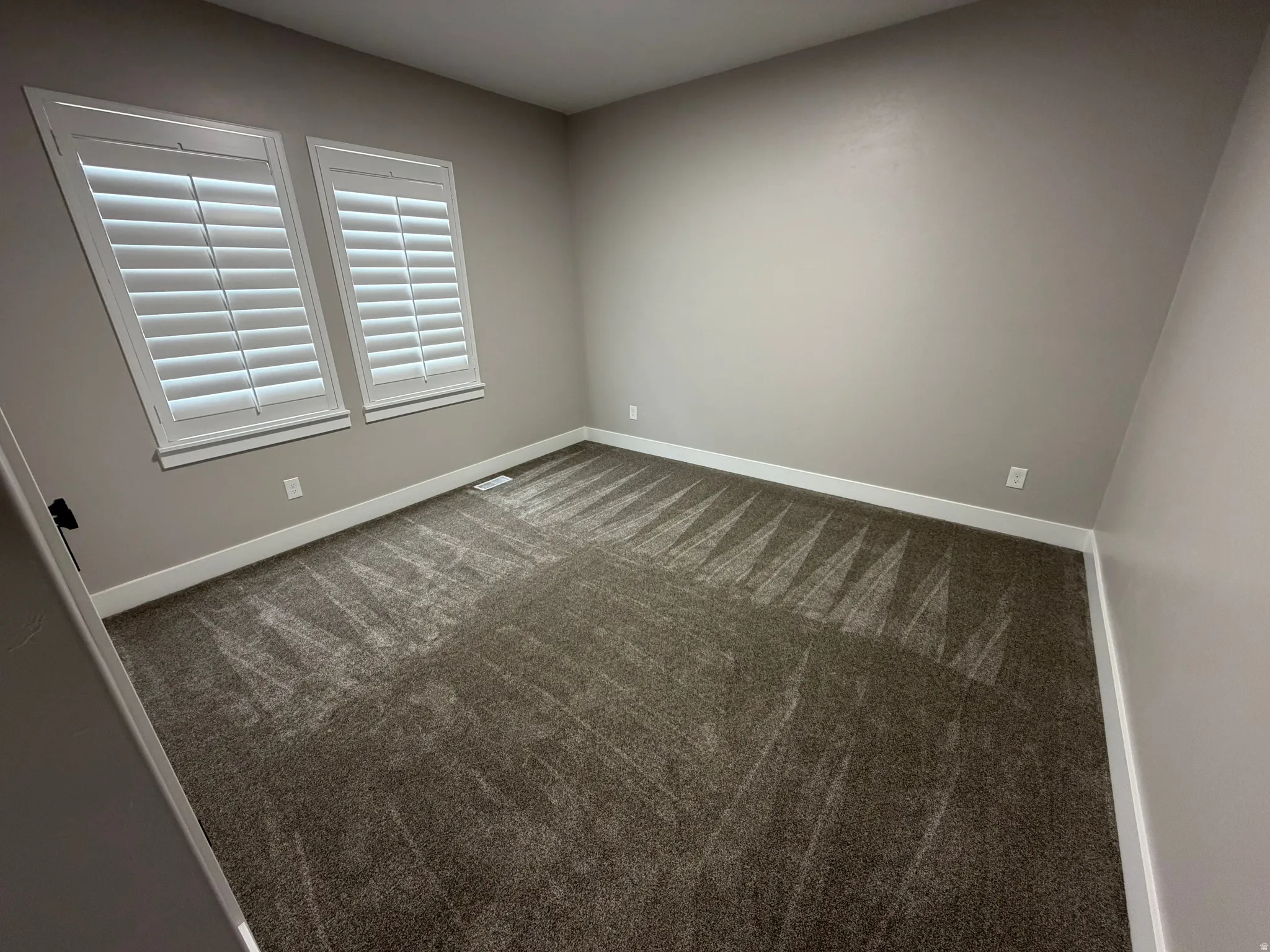 Carpeted spare room with baseboards