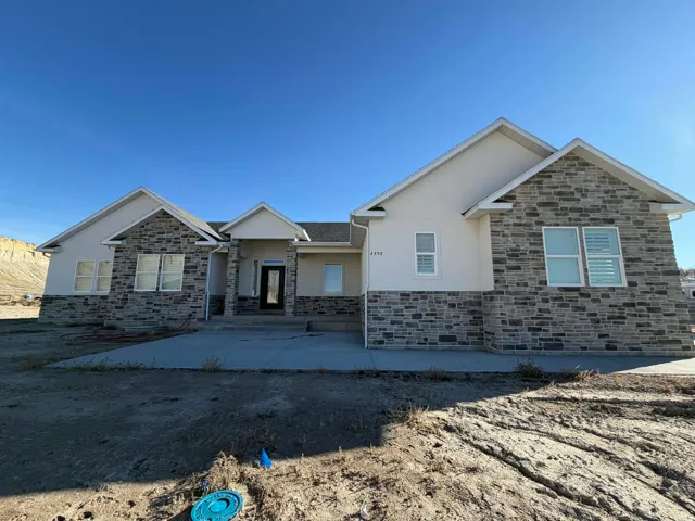 View of front of house with stucco siding and stone siding