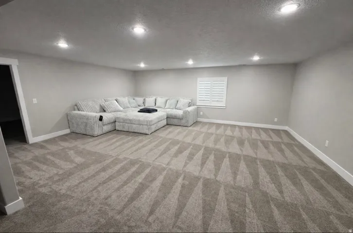 Unfurnished living room with a textured ceiling, recessed lighting, and light carpet