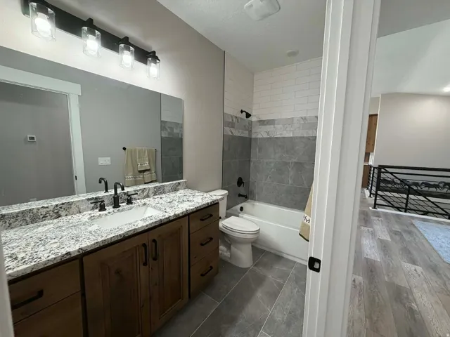 Bathroom featuring vanity, shower / bathtub combination, and a textured ceiling