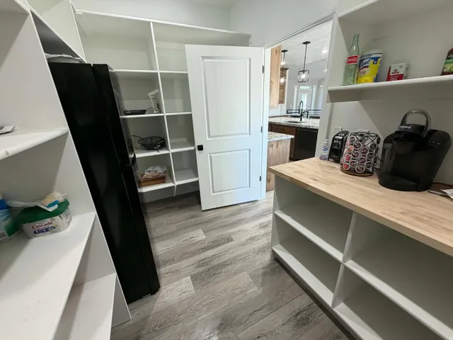 Walk in closet with light wood-style floors and a sink