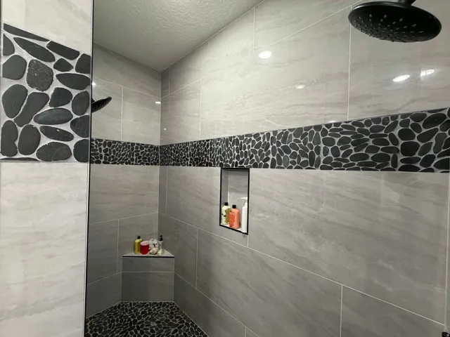 Full bath featuring a tile shower and a textured ceiling