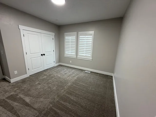 Unfurnished bedroom with carpet and a closet