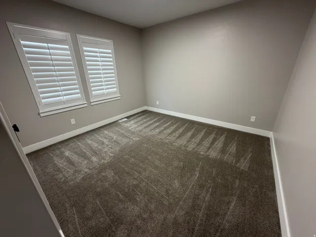 Carpeted spare room with baseboards