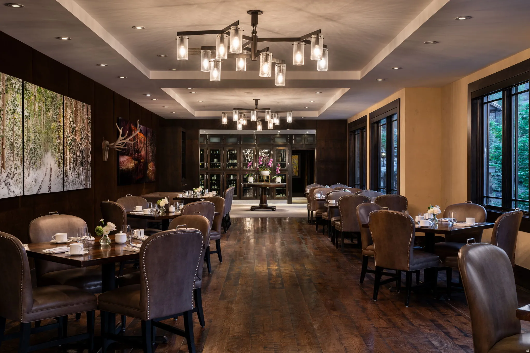 Dining space featuring a raised ceiling, dark wood-style flooring, recessed lighting, and a chandelier