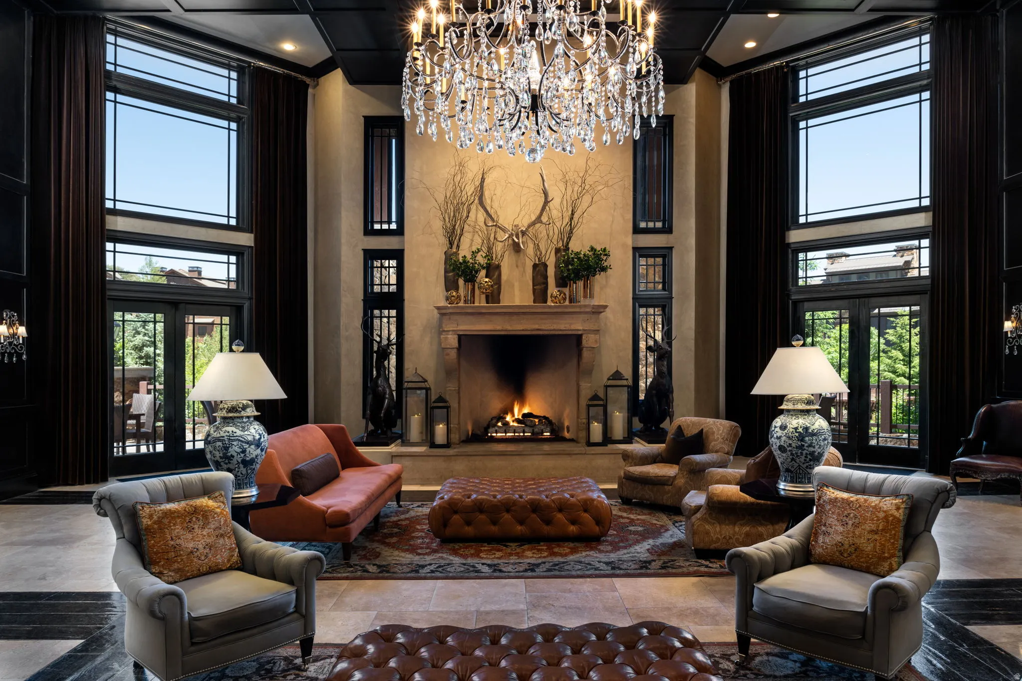 Sitting room featuring a premium fireplace, a high ceiling, french doors, and a chandelier