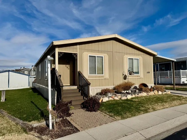 Manufactured / mobile home featuring a front yard and an attached carport
