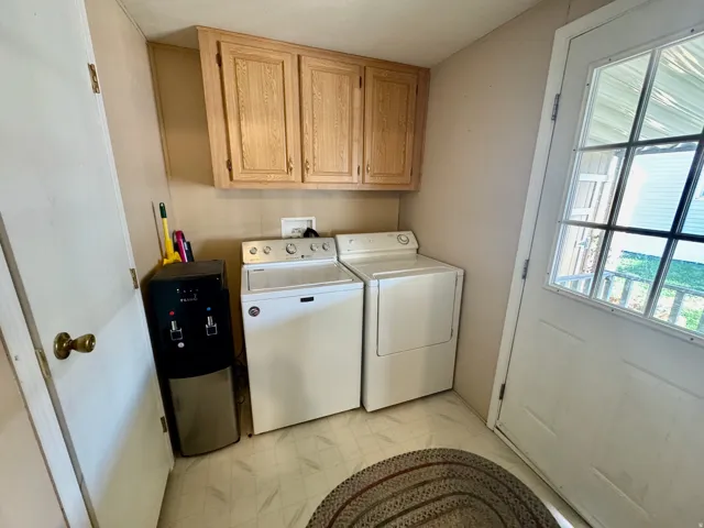 Laundry room featuring cabinet space, washing machine and dryer, and light flooring