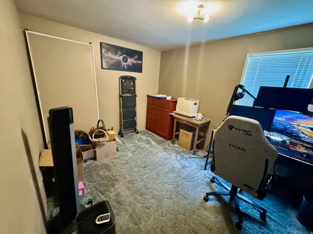 Office space featuring a textured ceiling and light colored carpet