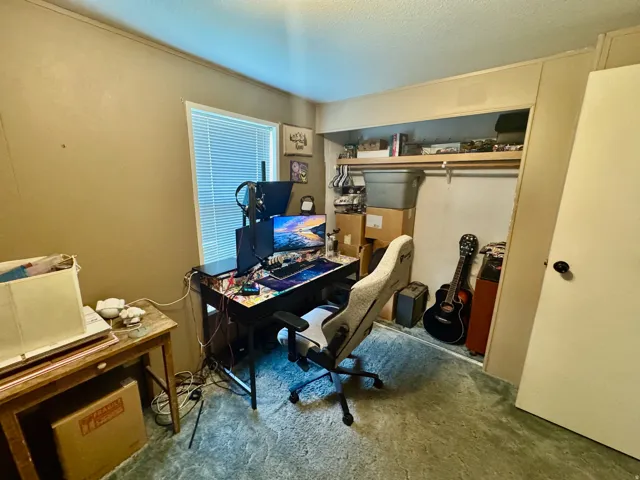 Office featuring a textured ceiling and carpet