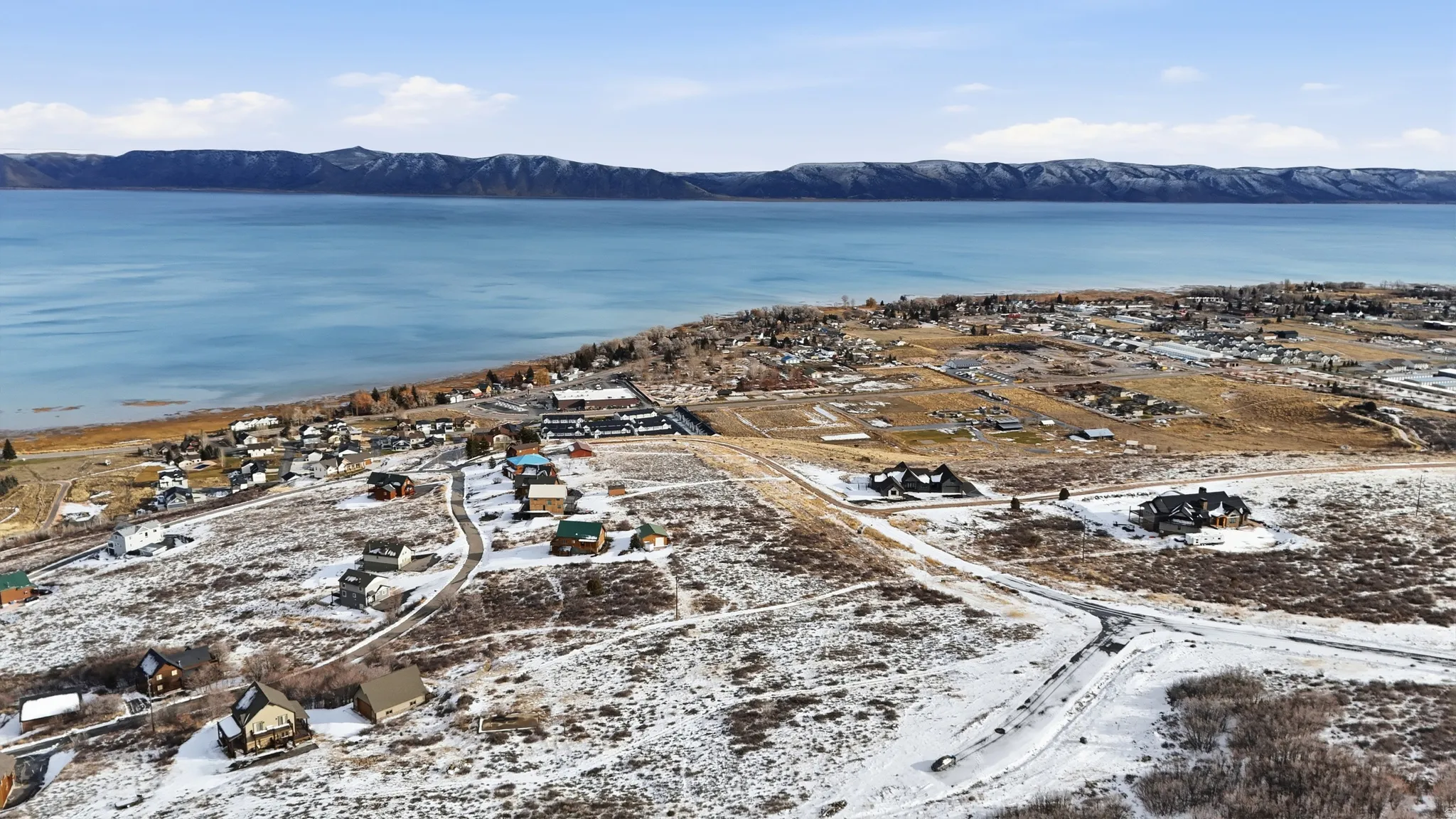 Aerial view of property's location featuring a mountainous background and nearby suburban area