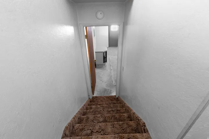 Stairs featuring a textured wall