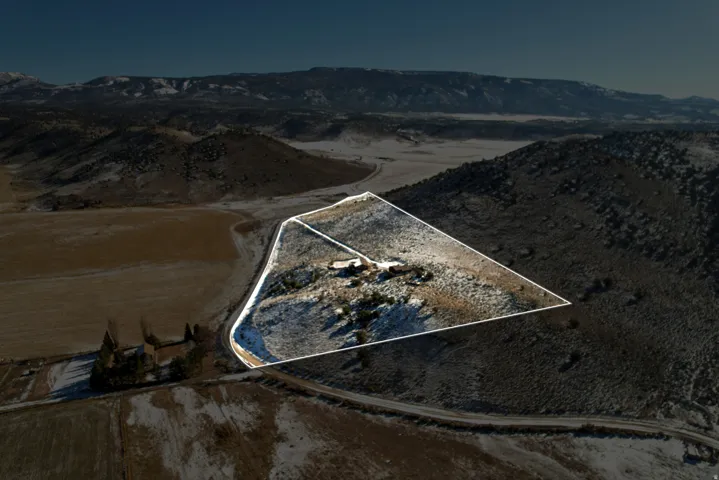 Aerial view of property and surrounding area featuring property boundaries highlighted and mountains
